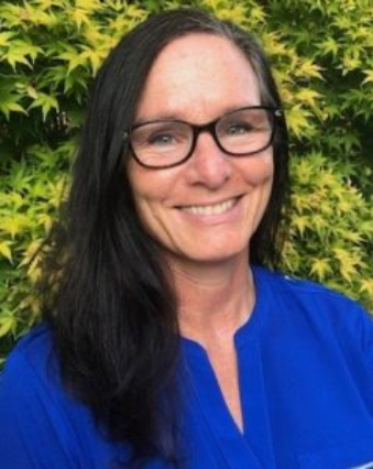 A woman with long black hair wearing glasses.