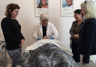 A group of people standing around a bed