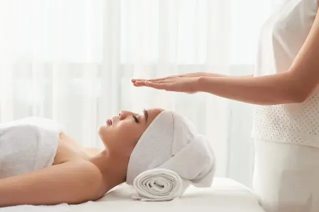 A woman getting her head shaved by an esthetician.